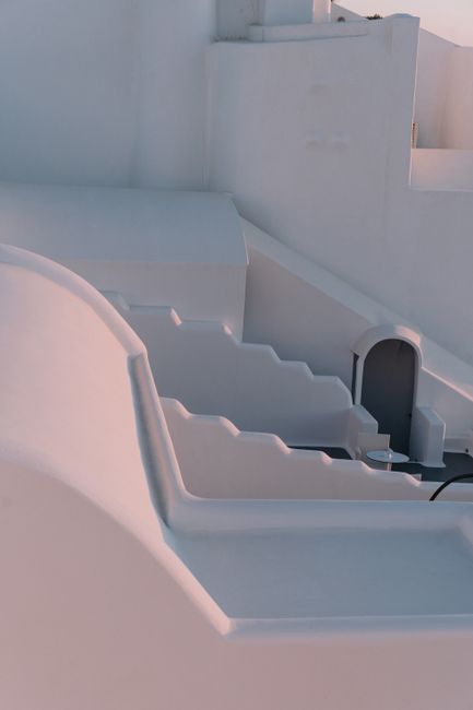 A serene view of white stucco architecture in soft sunlight, showcasing minimalist design.