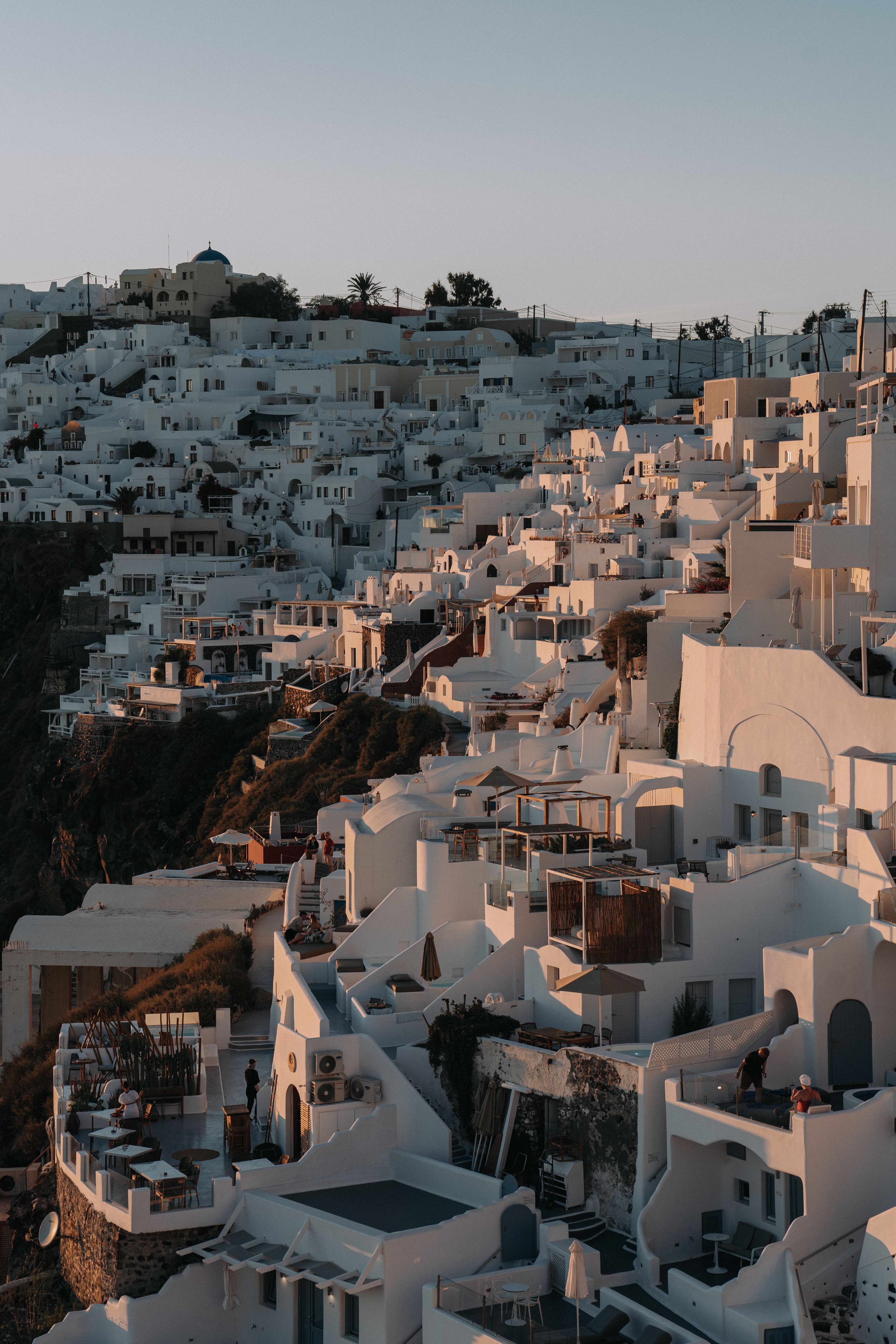 Capture of Santorini's iconic white architecture against a serene sunset sky, perfect for travel inspiration.