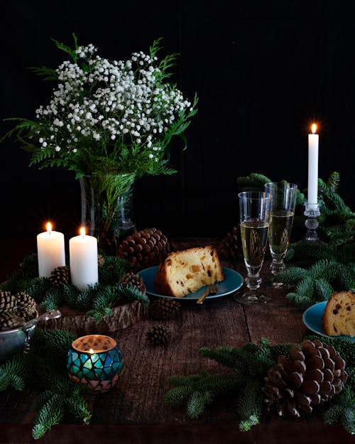 Lighted Candles on Brown Wooden Table With White Flowers on Glass Flower Vase