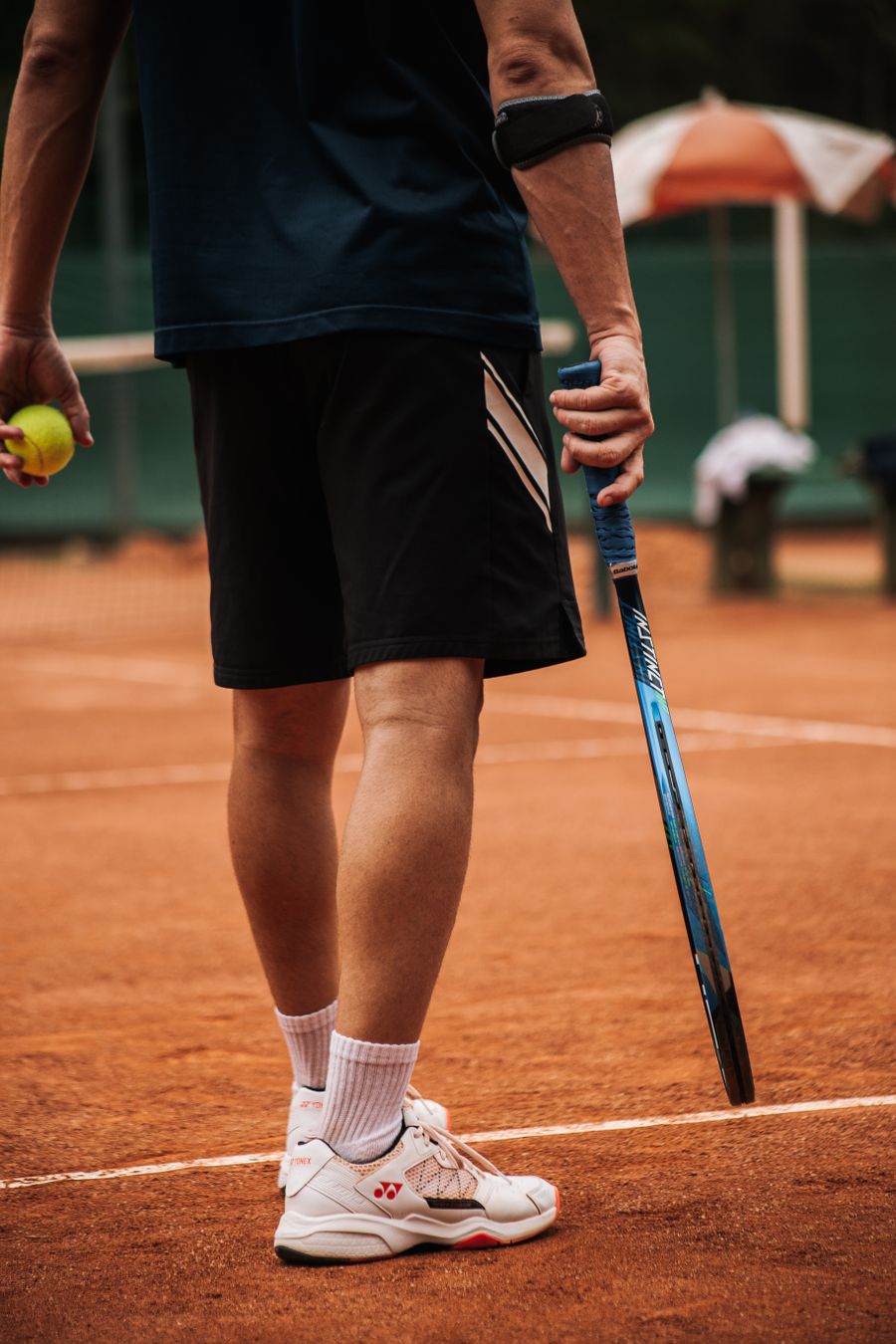 Player with racket and ball ready to serve on clay