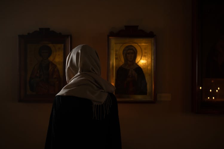 Woman In Scarf In Front Of Holy Painting