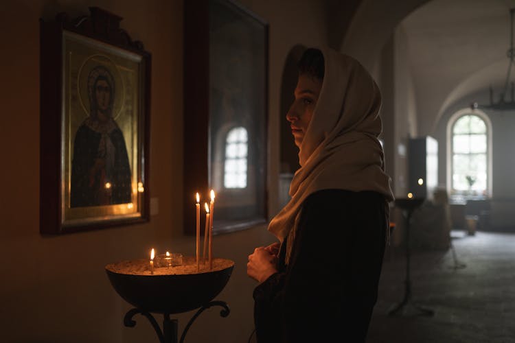 Woman In Church Looking At Icons 