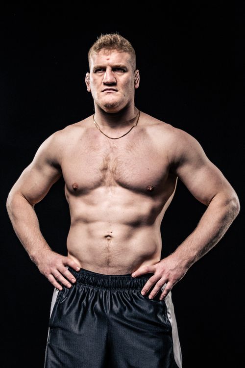 Free Shirtless bodybuilder showcasing muscular physique with intense expression on dark background. Stock Photo