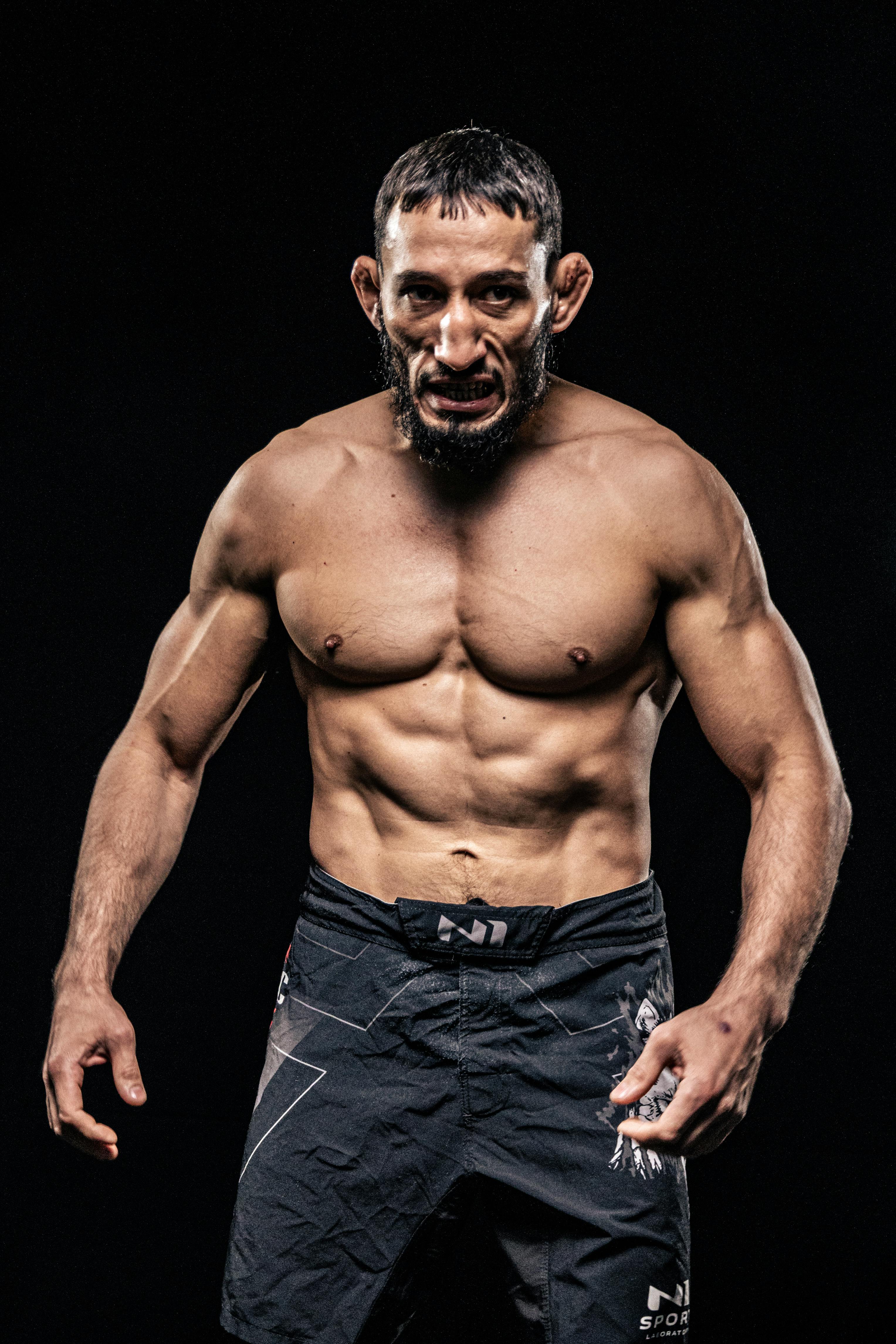 Powerful bodybuilder showcasing muscles against black backdrop, exuding strength and confidence.