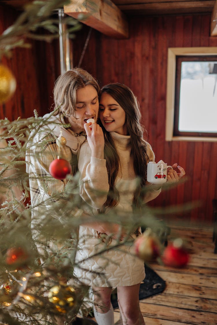 Happy Couple Eating Marshmallow Together On Christmas Day