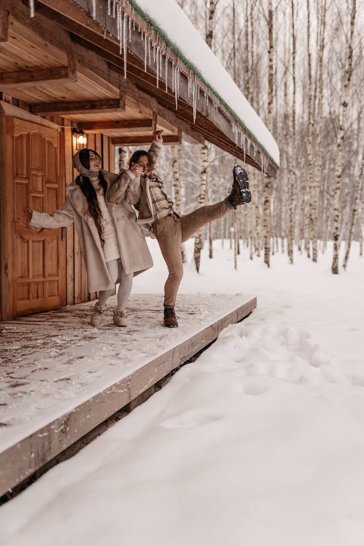 Man Slipping On Snow And Holding Hand Of Woman