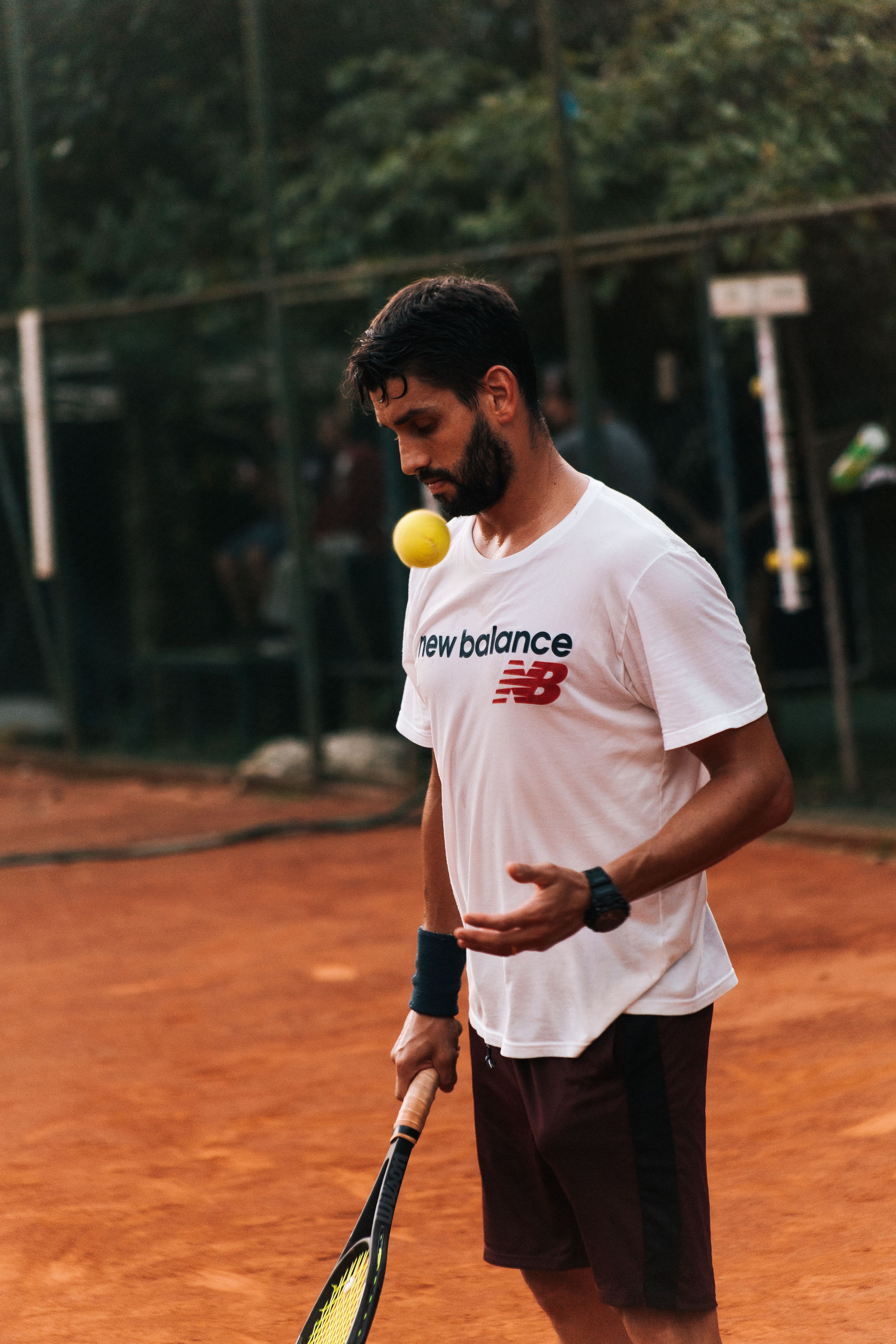 Athletic adult man in action with a tennis racket on a sunny clay court.