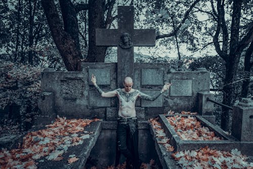 Shirtless Man Standing on Grave