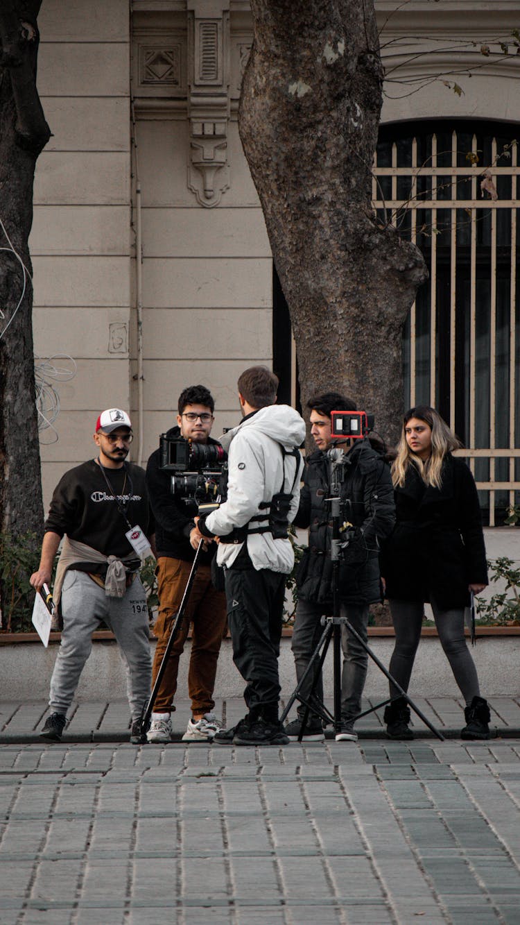 Group Of People On The Street With Their Camera Rig And Tripod