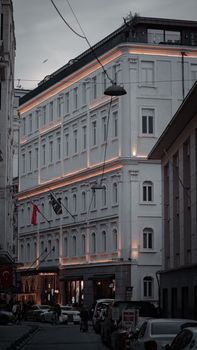 Capture of a classic Istanbul street with illuminated building facades at dusk.
