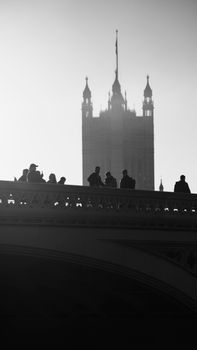 Silhouettes of people on Westminster Bridge with the Houses of Parliament in the background.