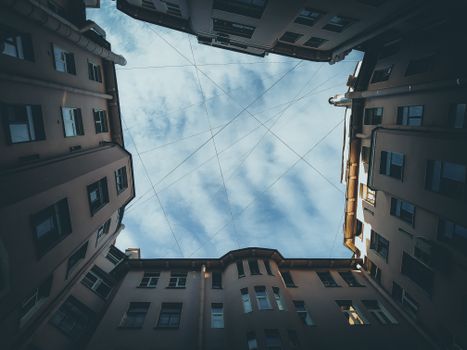 Dynamic low angle view of a Saint Petersburg building courtyard with a clear blue sky.