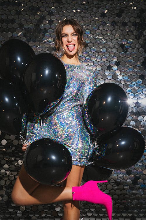A Woman Wearing a Shiny Dress with Black Balloons