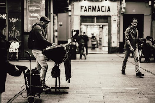 Black and white photo of a street musician playing a keyboard in a bustling city setting.