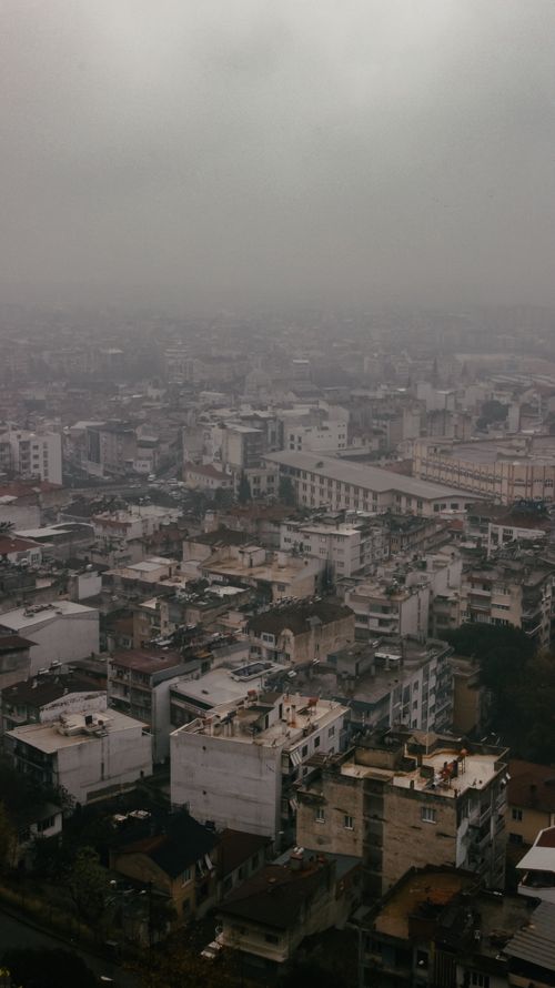 Free High-altitude view of an overcast urban skyline with dense building arrangement on a cloudy day. Stock Photo