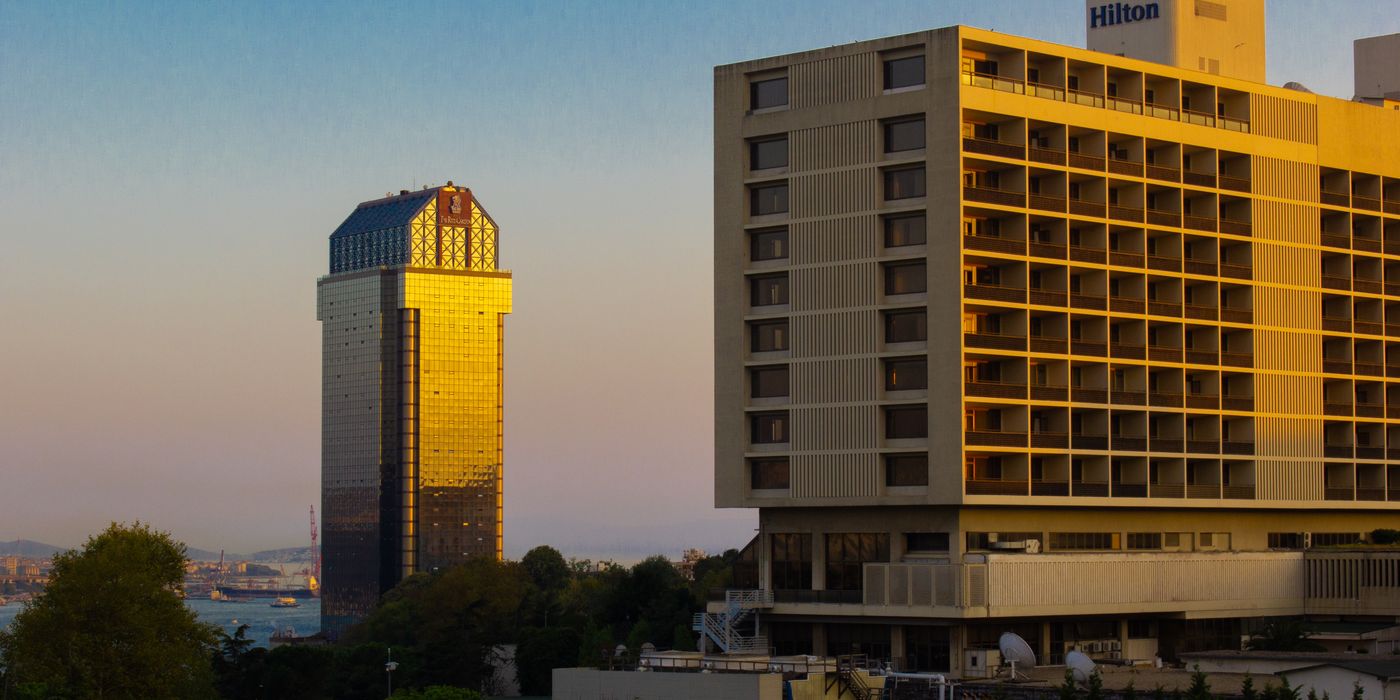 City hotel towers catching low sunset light above a downtown skyline