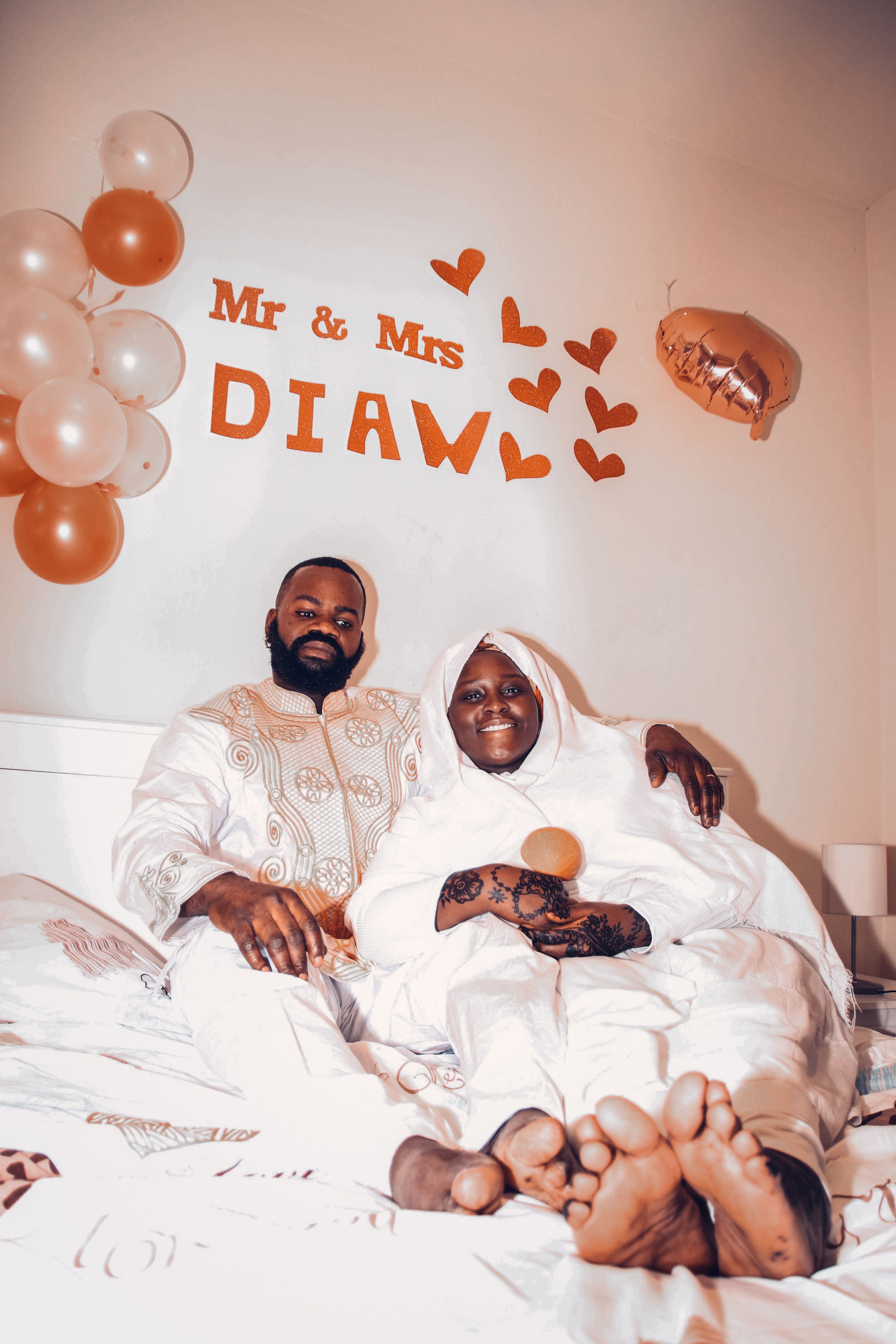 Joyful newlyweds enjoying a relaxing moment at home with decorative balloons.