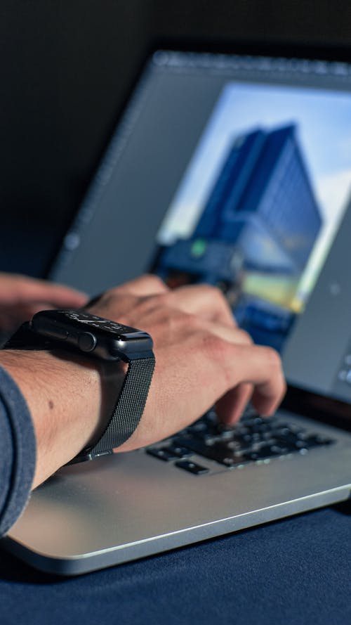 Free Person Wearing Black Watch Holding Black and Gray Laptop Computer Stock Photo
