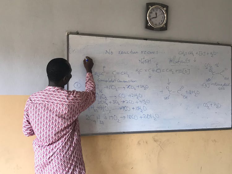 A Teacher Writing On A Whiteboard