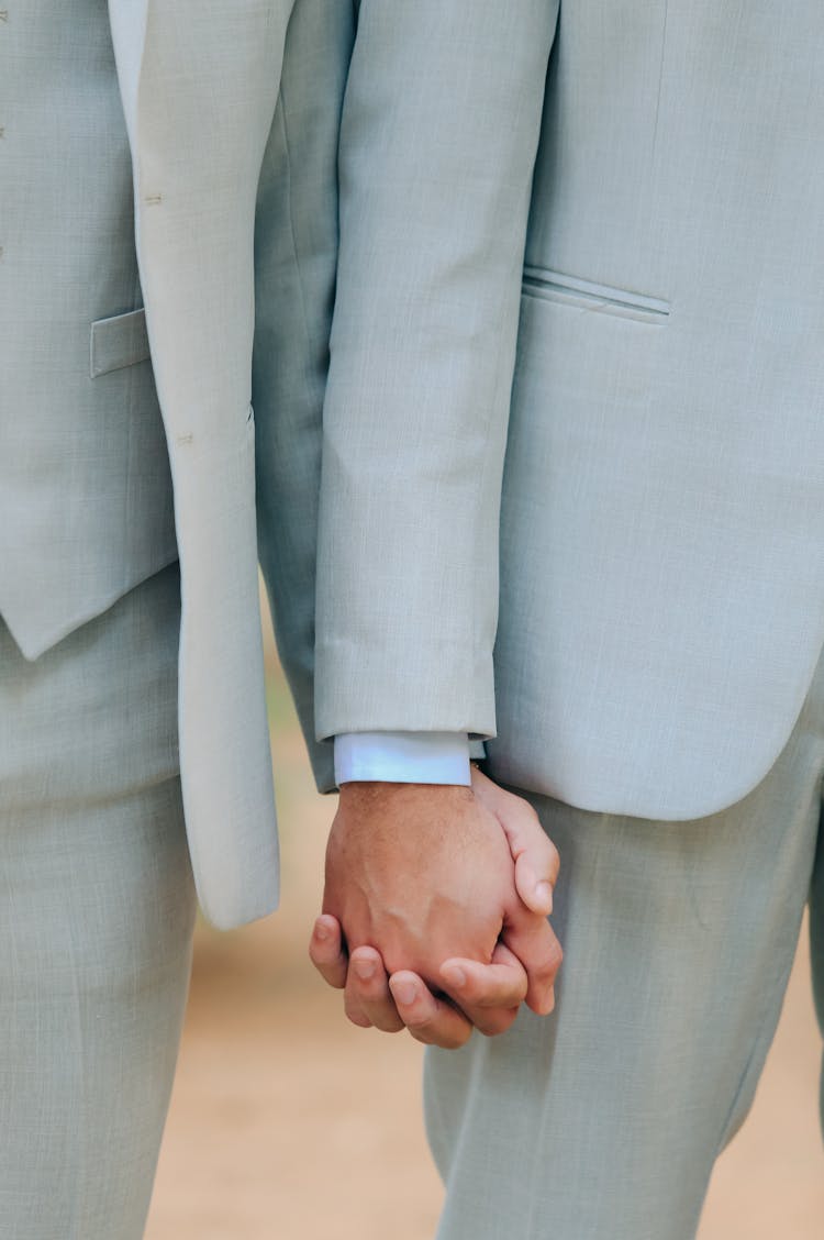 Holding Hands Of Gay Couple In Pale Blue Men Suits