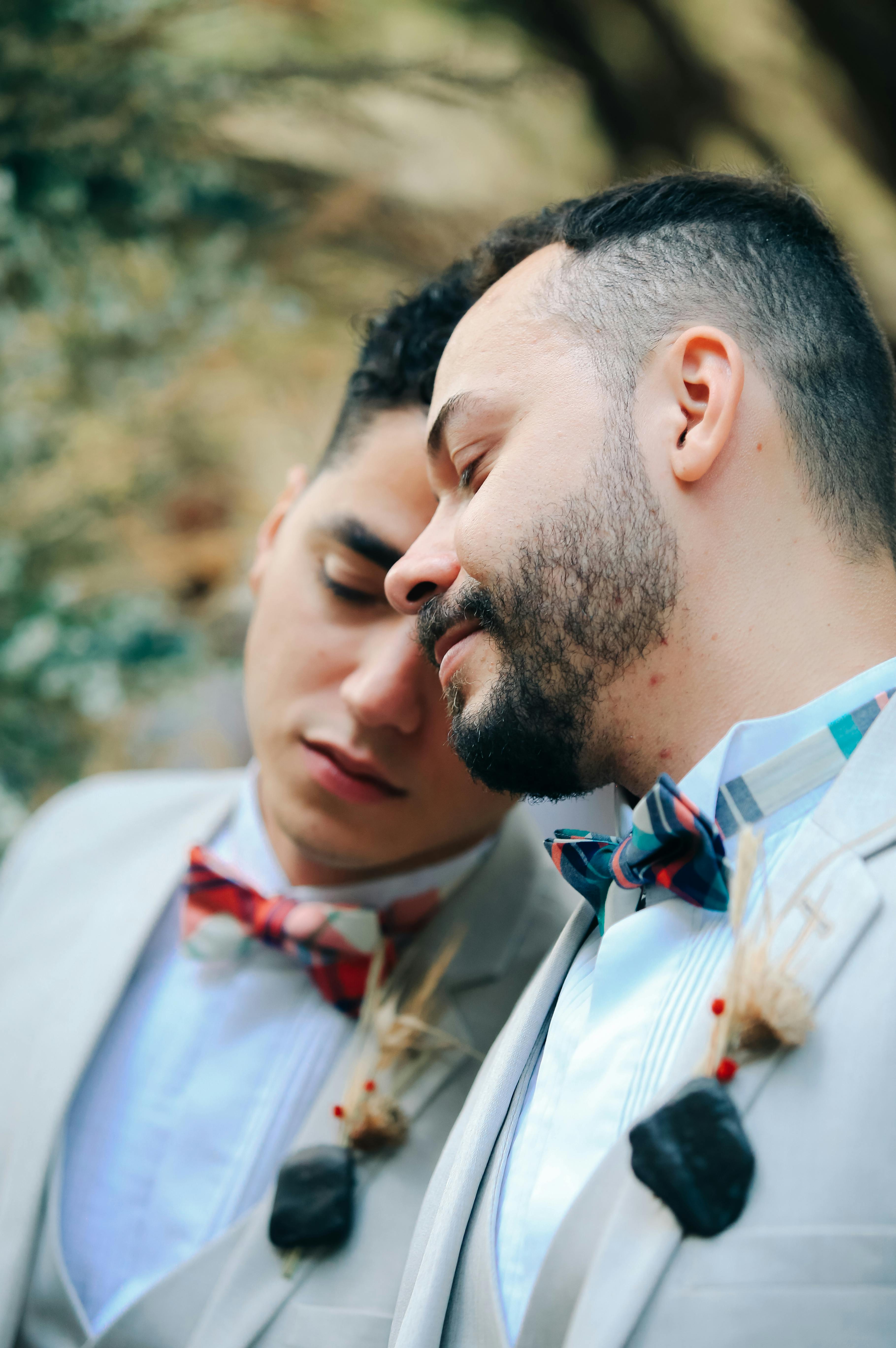 two young men wearing suits bowing heads towards each other