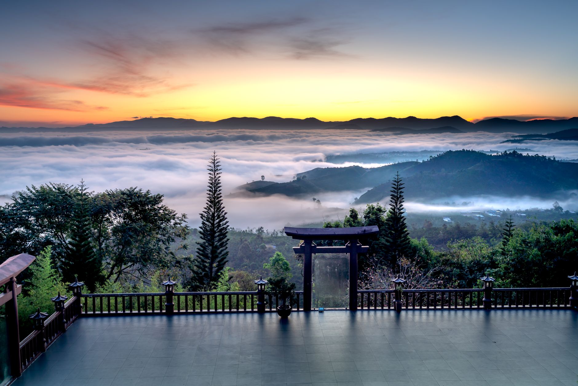 Enchanting sunrise view over misty mountains and clouds at Chua Linh Quy Phap An, Vietnam.