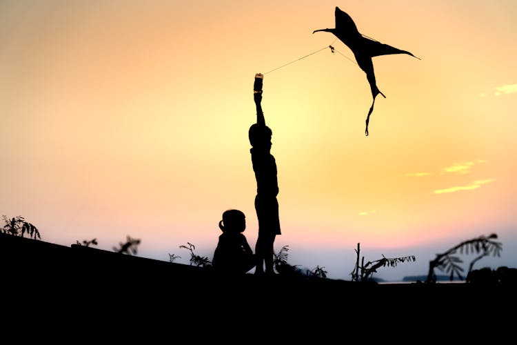 Boy And Girl With Kite At Sunset