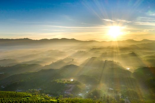 Majestic sunrise over misty hills, capturing nature's serene beauty and warm sunlight.