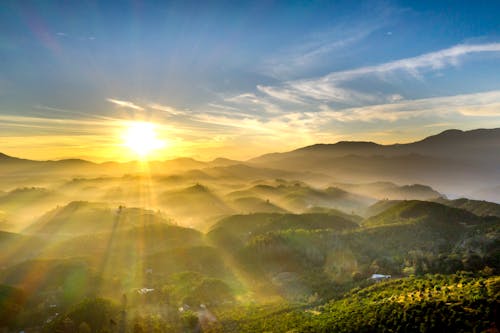 Green Grass Field and Mountains Under Blue Sky