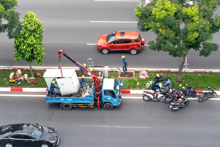 Workers Hauling Transformer Onto Truck