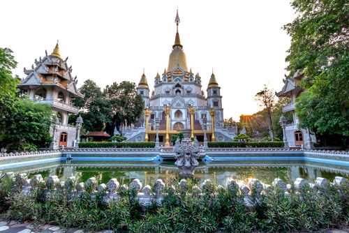 Free Buu Long Buddhist Temple facade reflecting in tranquil pond at dusk, capturing serene architecture. Stock Photo