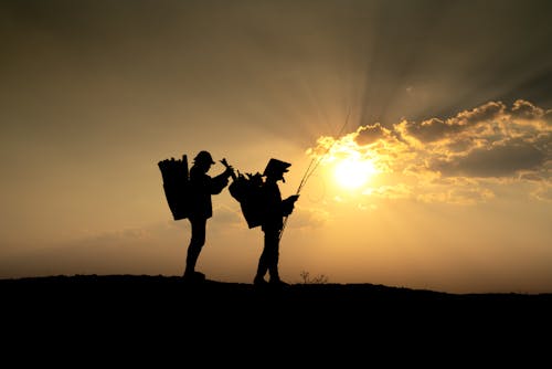 Foto d'estoc gratuïta de caminant, capvespre, cel taronja