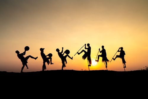 Free Silhouettes of stilt walkers and drummers at sunset, showcasing cultural celebration. Stock Photo