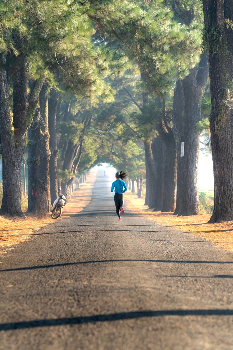 Woman Running Between Trees