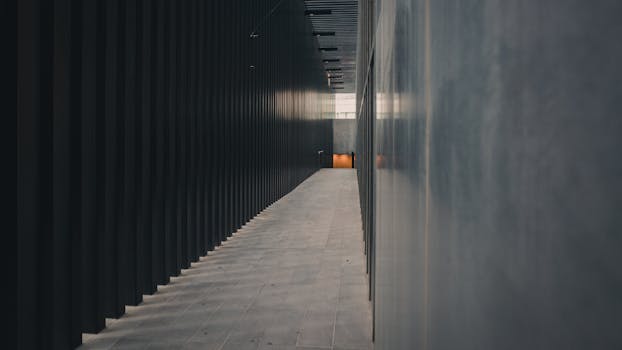 探索一条狭窄昏暗的走廊，现代建筑元素与柔和的光线反射交织其间