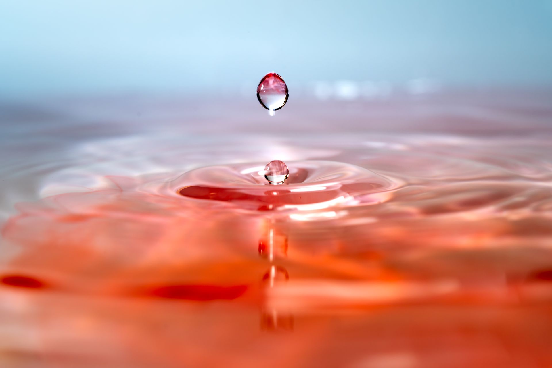 A mesmerizing macro photo of a water droplet hitting the surface, creating ripples.
