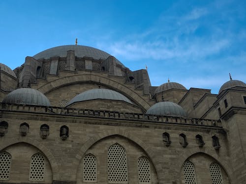 Brown Concrete Building with Dome Roofs Under Blue Sky