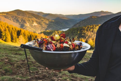 Person Holding a Bowl Full of Barbecue