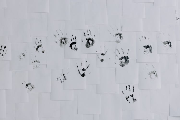 Hand Prints On White Papers Posted On A Wall