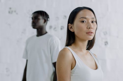 Free Portrait of diverse individuals in a minimalist studio setting, showcasing thoughtful expressions. Stock Photo