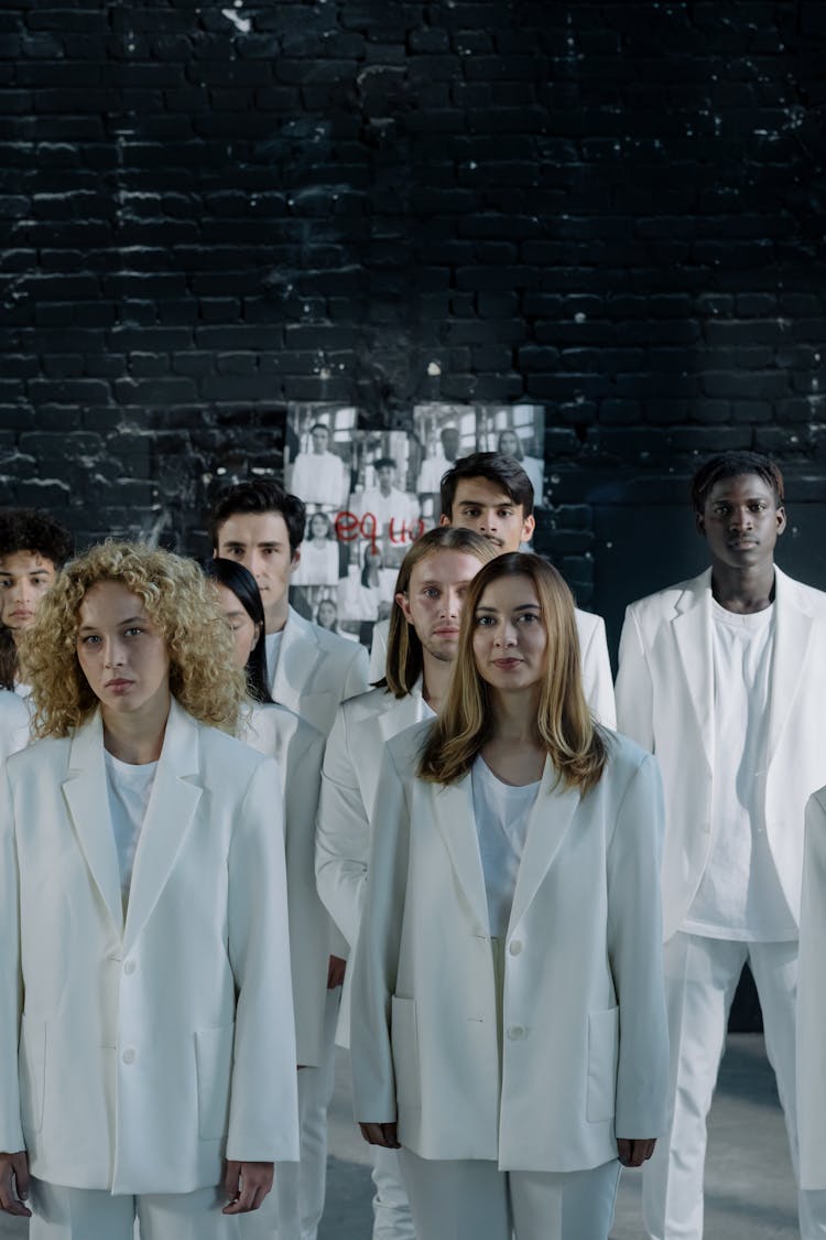 Group Of People Wearing White Blazers Standing Near Brick Wall