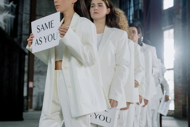 People In White Outfits Holding Placards