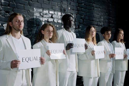 A diverse group of people in white attire holding signs that say 'Equal', promoting equality.