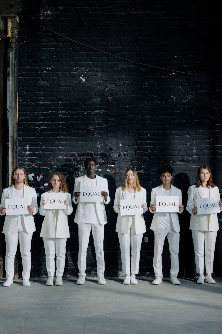 People In White Outfits Holding Placards