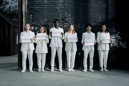 A Group of People Wearing White Uniform Standing while Holding a Printed Paper