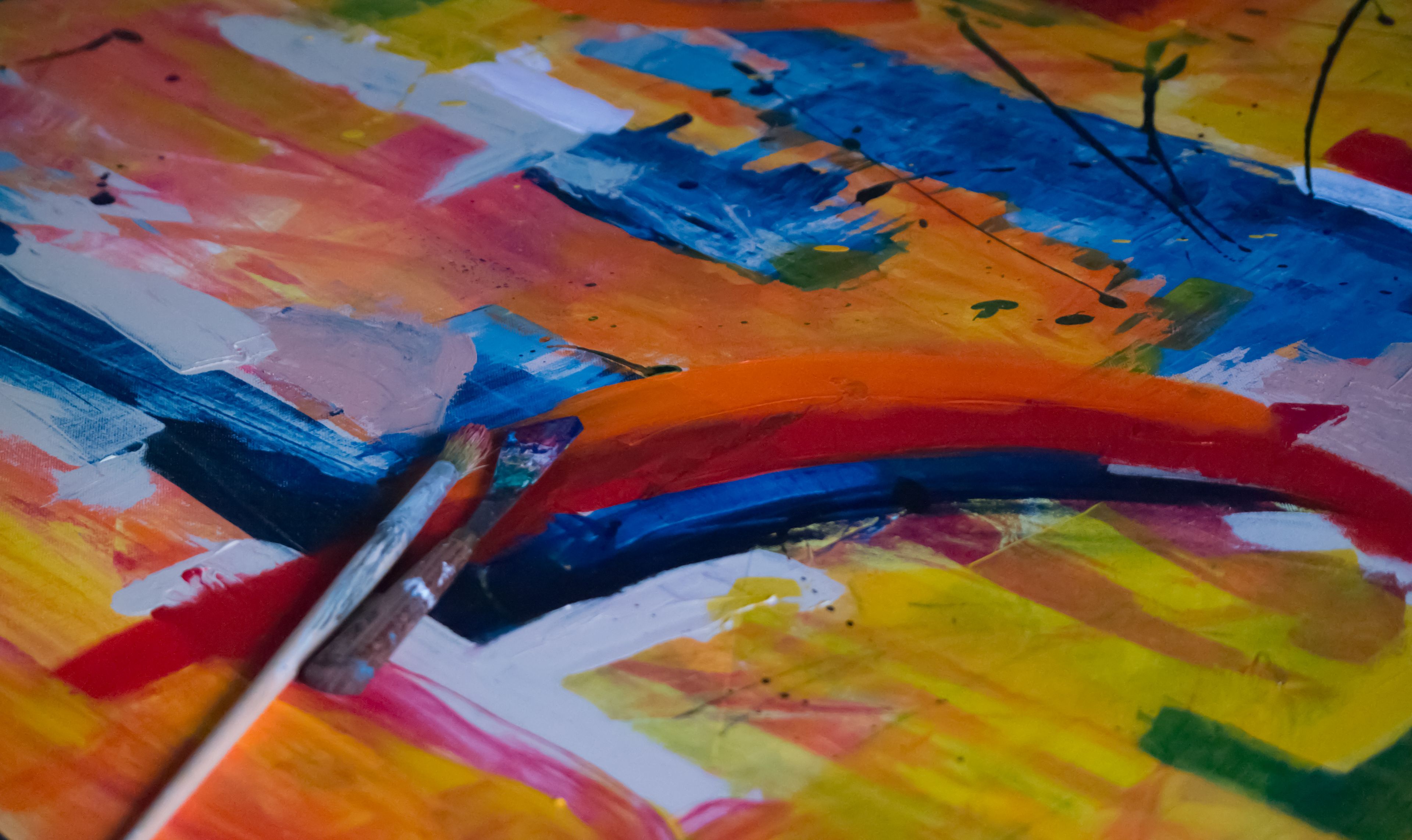 Thick acrylic strokes across a canvas, brush resting on the paint