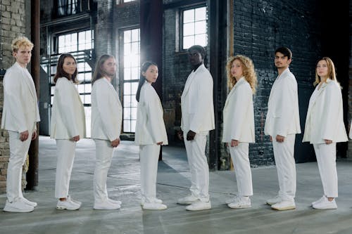 Group of Young People Wearing White Suits Standing in a Line 