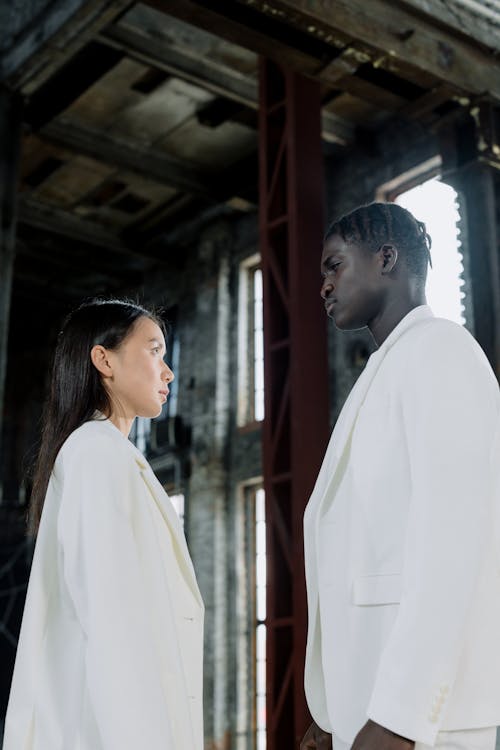 Couple in White Suits Standing Face to Face