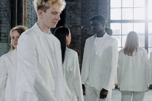 Group of Young People in White Clothing Standing Together in a Room 