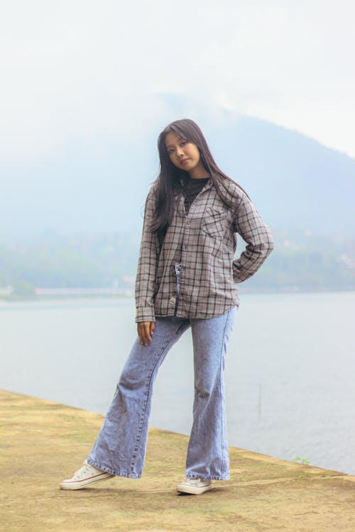 Free A Woman Wearing Long Sleeves and Denim Jeans Stock Photo